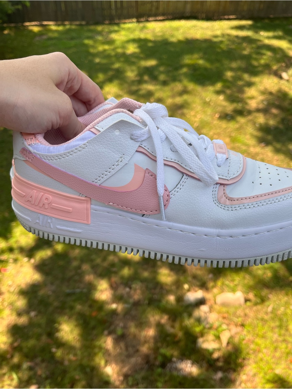 Nike woman’s Air Force 1 Shadow sneakers in white with a soft blush pink accent.